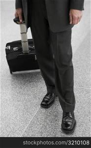 Low section view of a businessman with a luggage