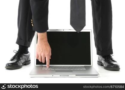 Low section view of a businessman working on a laptop between his leg