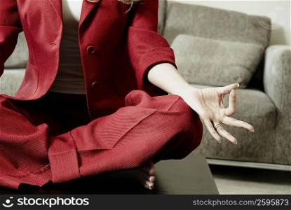 Low section view of a businesswoman meditating