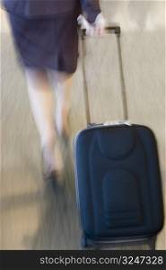Low section view of a businesswoman pulling her luggage
