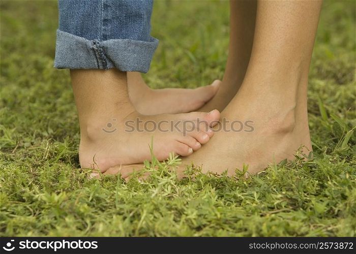 Low section view of a child feet on an adult&acute;s feet