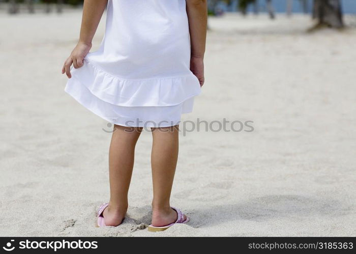 Low section view of a girl standing on the beach