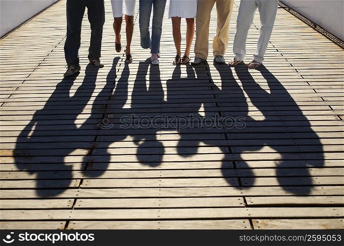 Low section view of a group of friends standing on a footbridge