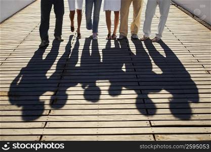 Low section view of a group of friends standing on a footbridge