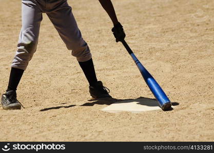 Low section view of a man holding a baseball bat