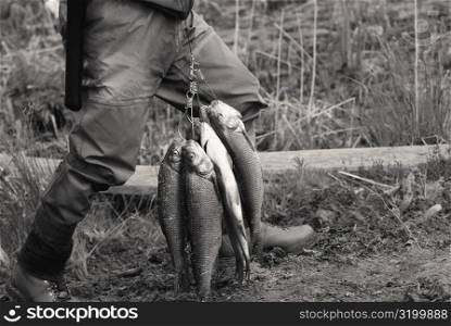 Low section view of a man holding fish