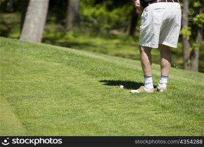 Low section view of a man playing golf on a golf course