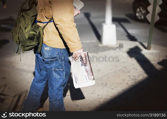 Low section view of a man selling newspapers