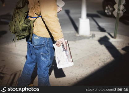 Low section view of a man selling newspapers