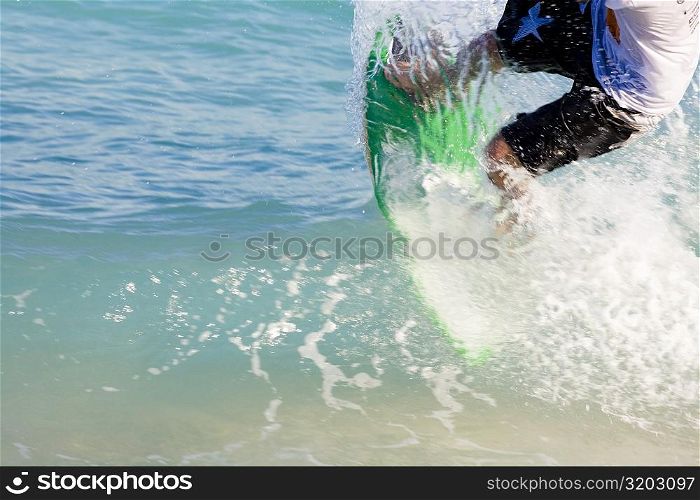 Low section view of a man surfing on a surfboard