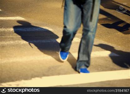 Low section view of a man walking on the road