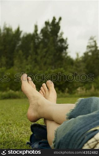 Low section view of a mid adult man lying on the grass