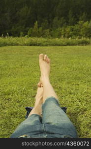 Low section view of a mid adult man lying on the grass