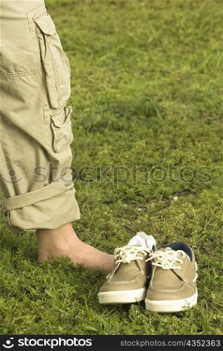 Low section view of a mid adult man standing on the grass