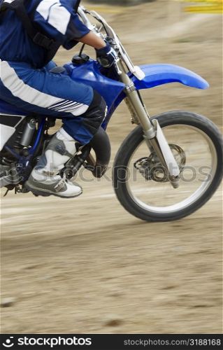Low section view of a motocross rider riding a motorcycle
