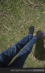 Low section view of a person&acute;s feet hanging over a lawn