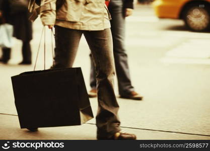 Low section view of a person carrying a shopping bag