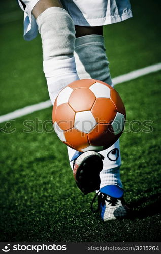 Low section view of a person kicking a ball