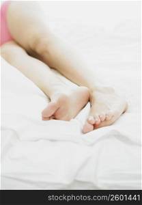 Low section view of a person lying on the bed
