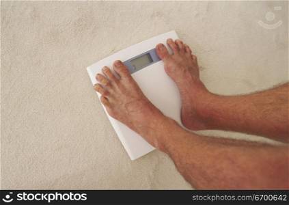 Low section view of a person standing on a weighing scale