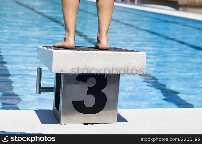 Low section view of a person standing on the diving platform