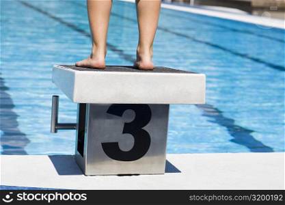 Low section view of a person standing on the diving platform