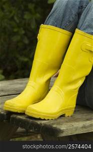 Low section view of a person wearing rubber boots