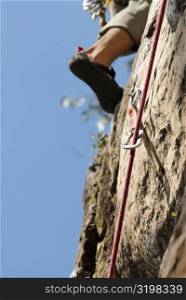 Low section view of a rock climber scaling a rock face