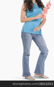 Low section view of a teenage girl holding flowers