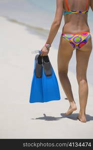 Low section view of a woman standing on the beach, West Bay Beach, Roatan, Bay Islands, Honduras