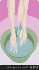 Low section view of a woman submerging her feet in a tub of water