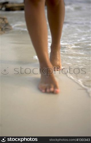 Low section view of a woman walking on the beach