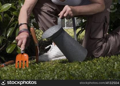 Low section view of a woman watering plants