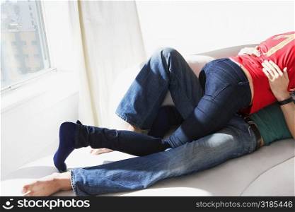 Low section view of a young couple romancing on the bed