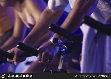 Low section view of people cycling in a gym