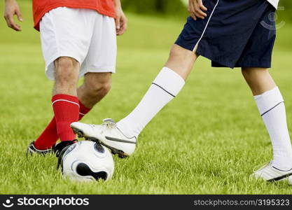 Low section view of two soccer players playing soccer