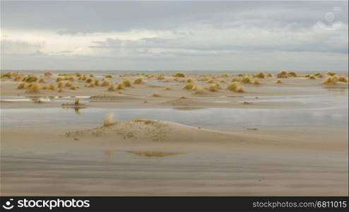 Low tide at the dunes of Ameland, dark sky, Holland