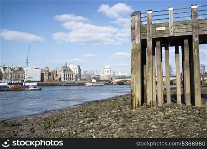 Low tide River Thames and London city skyline including St Paul&rsquo;s Cathedral
