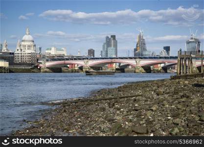 Low tide River Thames and London city skyline including St Paul&rsquo;s Cathedral