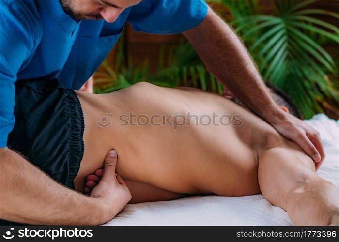 Lower back sports massage physical therapy. Physical therapist massaging injured lower back. . Lower Back Sports Massage Physical Therapy