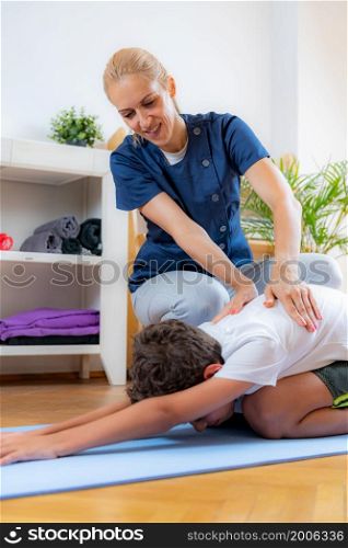 Lower back stretch. Boy exercising with physical therapist.. Lower back stretch with physical therapist.