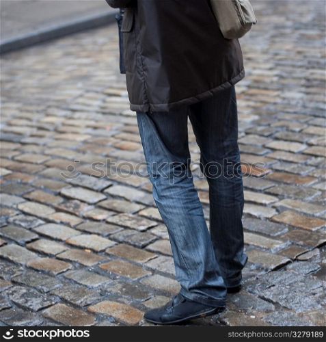 Lower portion of a man standing on a street in Manhattan, New York City, U.S.A.
