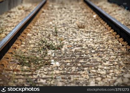 Lower view of train tracks with gravel.