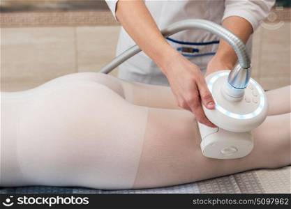 LPG, and body contouring treatment in clinic. Woman in special white suit getting anti cellulite massage in a spa salon. LPG, and body contouring treatment in clinic. Lipomassage procedure on female body.