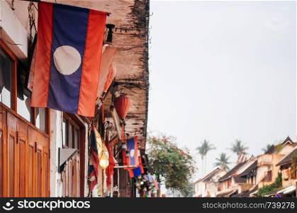 Luang Prabang, Laos - Many Laos Flags haging at old building front on Luang Prabang street with copy space