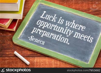 Luck is where opportunity meets preparation - Seneca quote on a slate blackboard with a white chalk and a stack of books against rustic wooden table