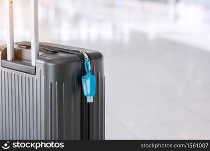 Luggage bag with alcohol gel hand sanitizer in international airport terminal, protection Coronavirus disease (Covid-19) infection. New Normal and travel bubble concepts