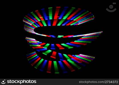 Luminous colors of rainbow trail in form of spiral on black background. Isolated.