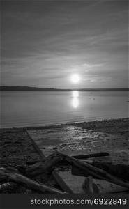 Luminous light envelops everything as the sun sets over the Puget Sound. Black and white image.