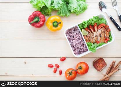 Lunch box, grilled chicken breast with tomatoes, lettuce and ste. Lunch box, grilled chicken breast with tomatoes, lettuce and steam rice. Top view on wooden background, Healthy lifestyle concept